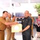 Pj Wali Kota Kotamobagu, Asripan Nani saat menyerahkan SPPDT PBB, (Foto: Diskominfo).