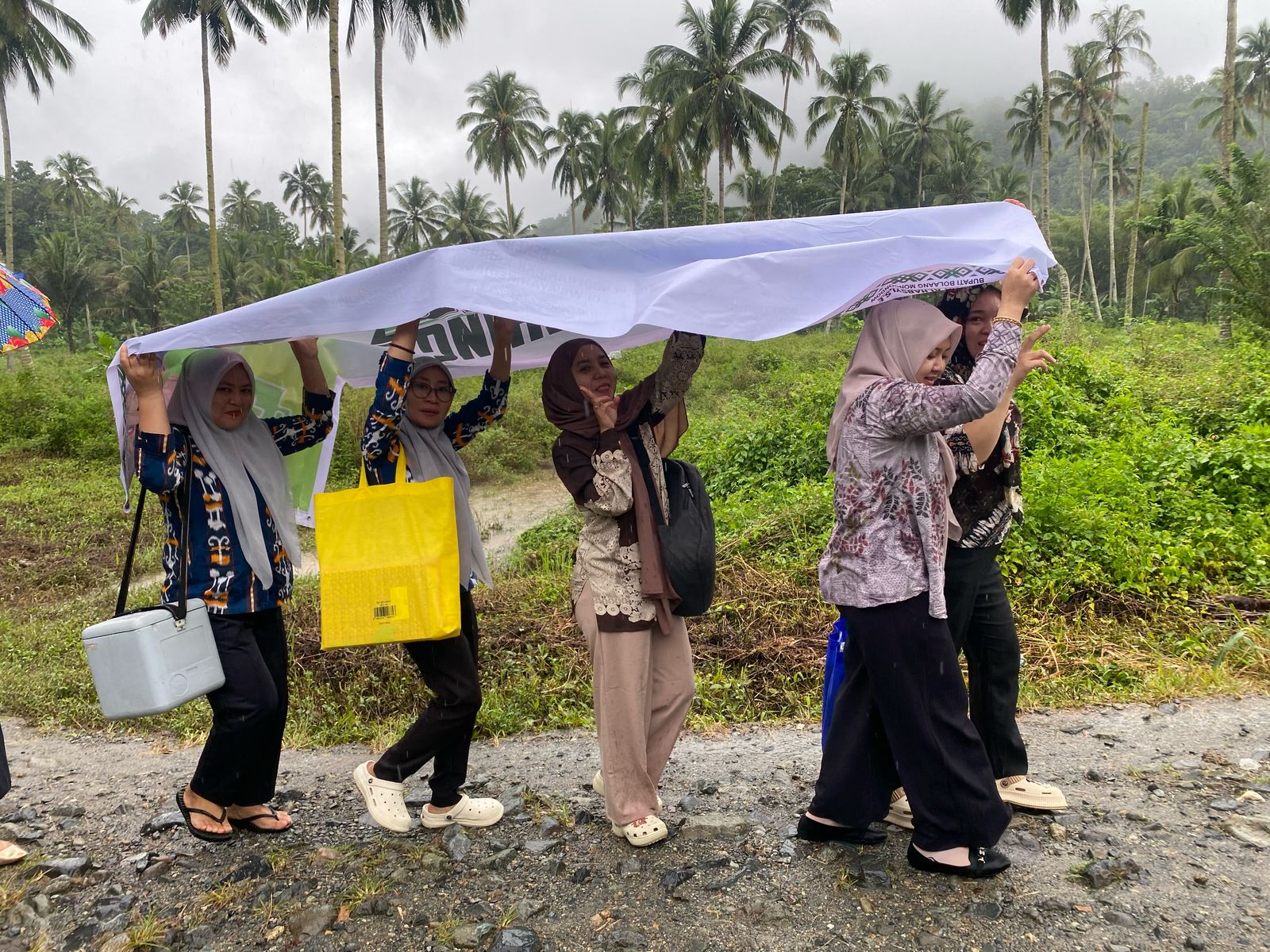 Menembus hujan dan jalan berbatu, petugas Puskesmas Tanoyan tak surut layani warga Mengkang 9 Menembus hujan dan jalan berbatu, petugas Puskesmas Tanoyan tak surut layani warga Mengkang